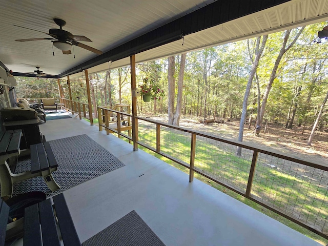 unfurnished sunroom featuring ceiling fan and plenty of natural light