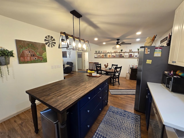 kitchen featuring hanging light fixtures, dark hardwood / wood-style flooring, white cabinetry, wood counters, and blue cabinetry