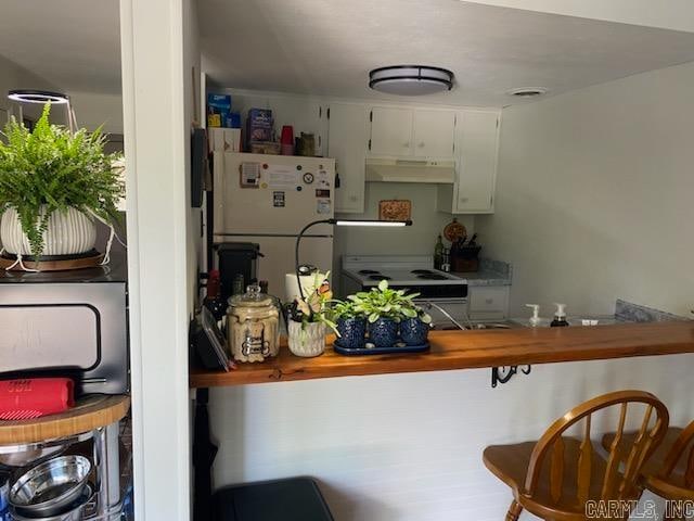 kitchen with white appliances, wooden counters, and white cabinets