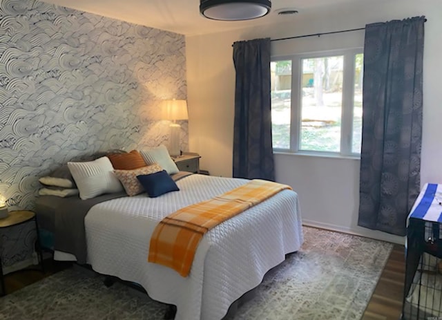 bedroom featuring multiple windows and hardwood / wood-style flooring