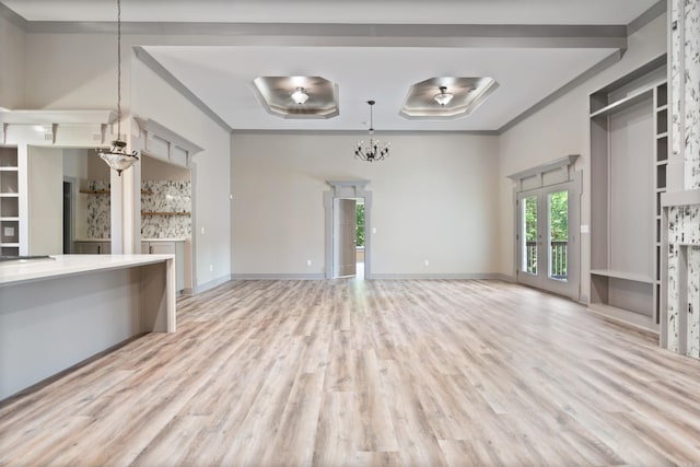 unfurnished living room featuring crown molding, french doors, and light wood-type flooring