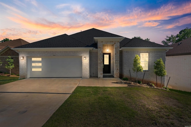 prairie-style house featuring a garage and a lawn