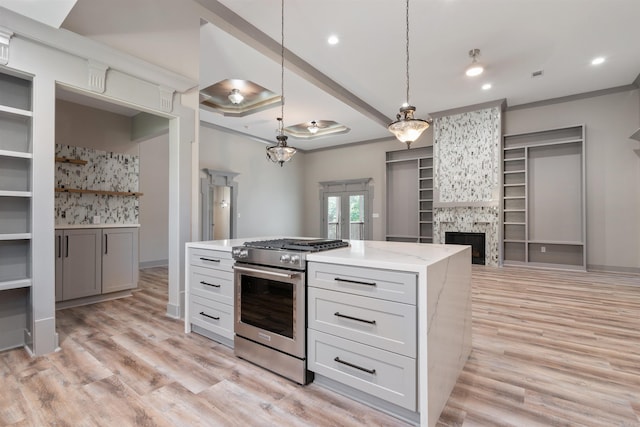 kitchen featuring light hardwood / wood-style floors, a fireplace, pendant lighting, and stainless steel stove