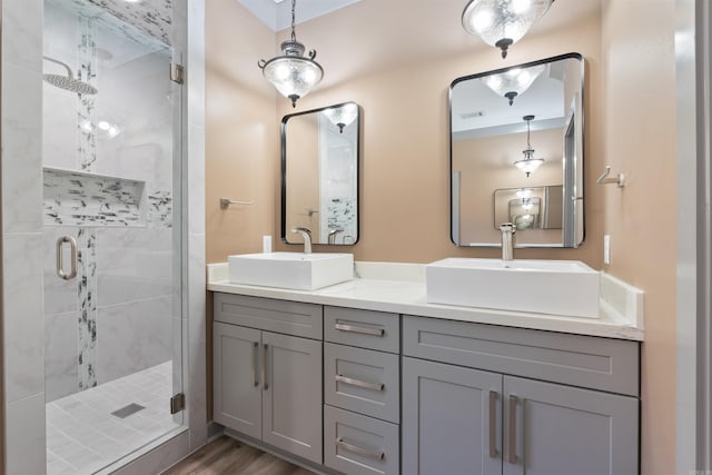 bathroom with a shower with door, hardwood / wood-style flooring, and vanity