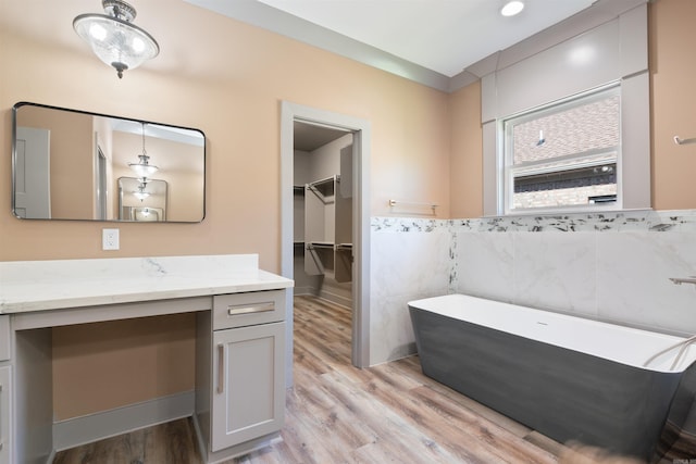 bathroom featuring vanity, a tub, and wood-type flooring