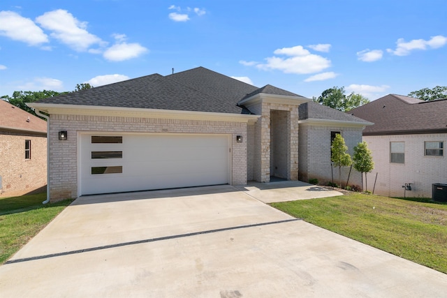 view of front of house with a front yard, cooling unit, and a garage