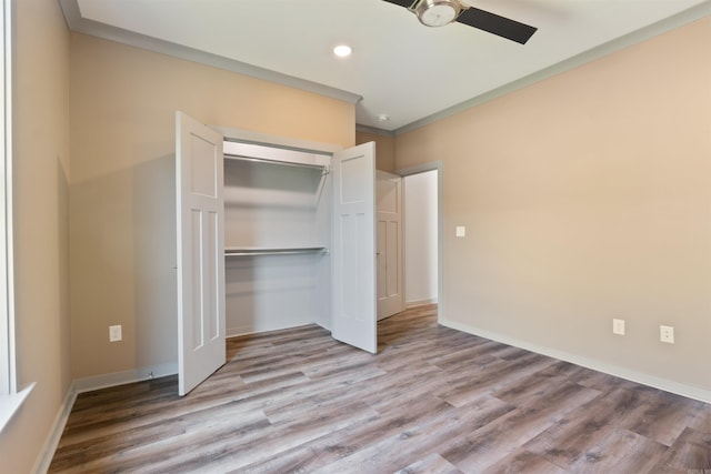 unfurnished bedroom featuring crown molding, light hardwood / wood-style flooring, a closet, and ceiling fan