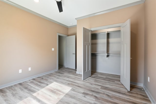 unfurnished bedroom featuring light hardwood / wood-style floors, a closet, ornamental molding, and ceiling fan