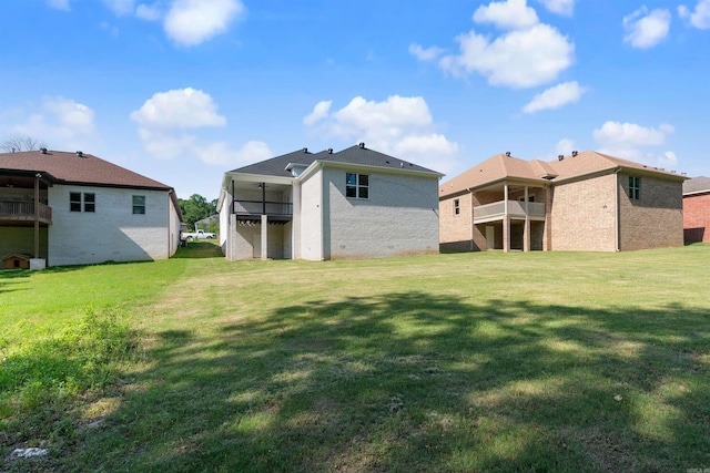 back of house featuring a yard and a balcony