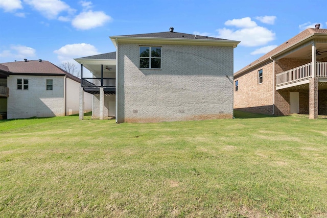 back of house featuring a balcony and a yard