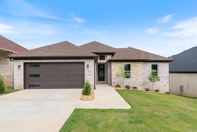 prairie-style house featuring a front yard and a garage