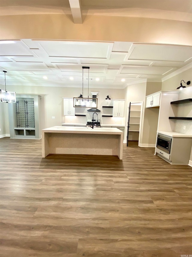 kitchen featuring hanging light fixtures, an island with sink, white cabinetry, light wood-type flooring, and coffered ceiling