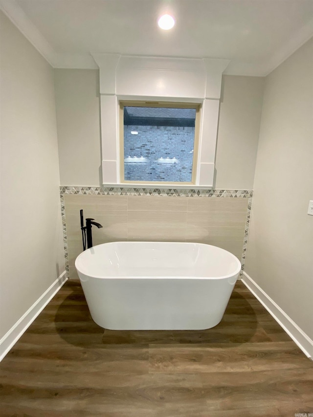 bathroom featuring tile walls, a bathing tub, and hardwood / wood-style floors