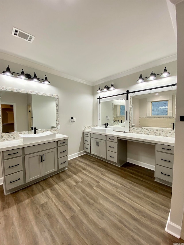 bathroom with vanity, crown molding, and wood-type flooring