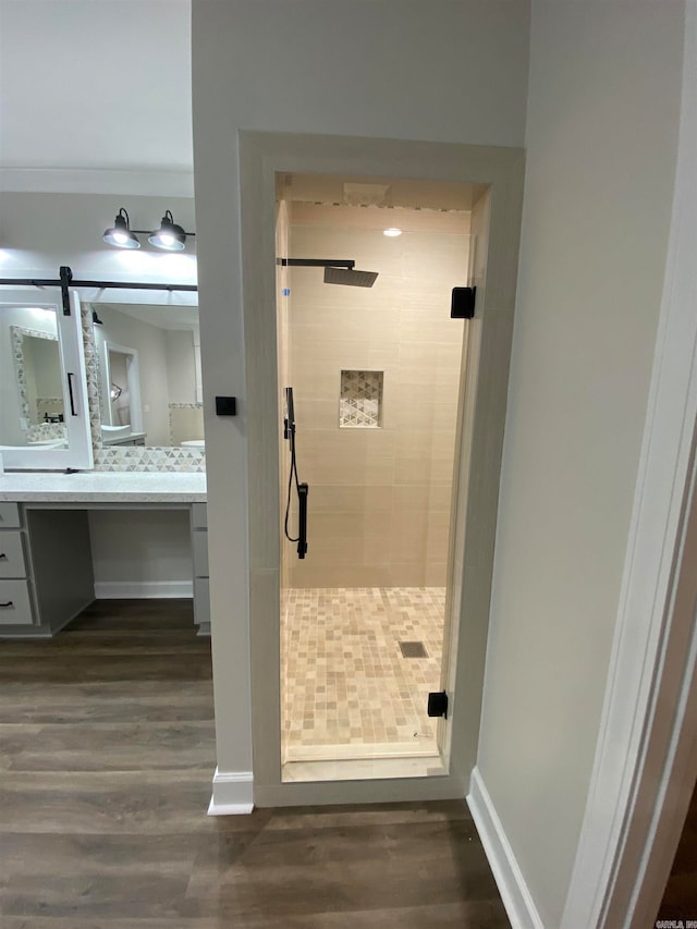 bathroom featuring vanity, wood-type flooring, and tiled shower