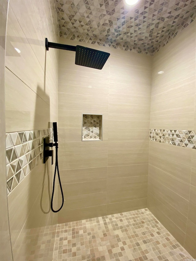 bathroom with a tile shower and tile walls