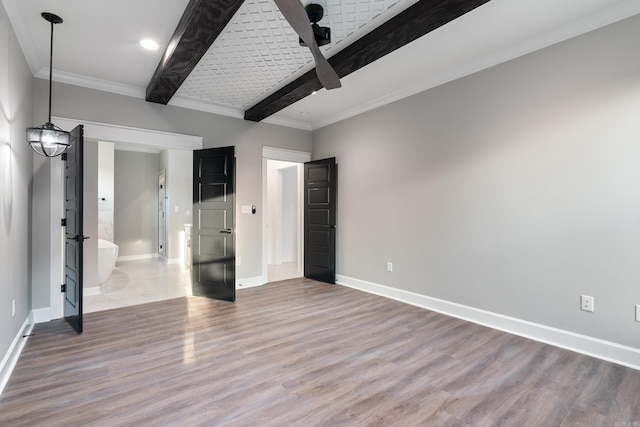 unfurnished bedroom featuring hardwood / wood-style flooring, beamed ceiling, and connected bathroom