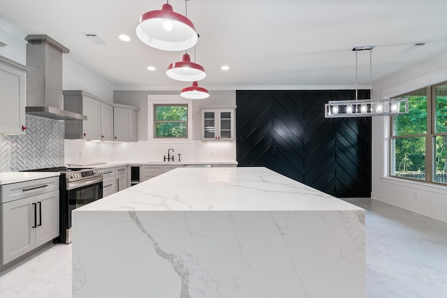 kitchen featuring gray cabinets, decorative light fixtures, wall chimney exhaust hood, and electric stove