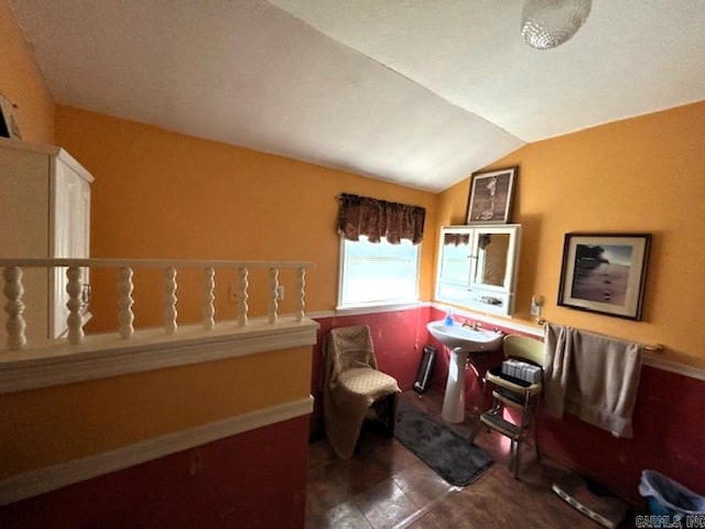 sitting room featuring dark tile patterned floors and vaulted ceiling