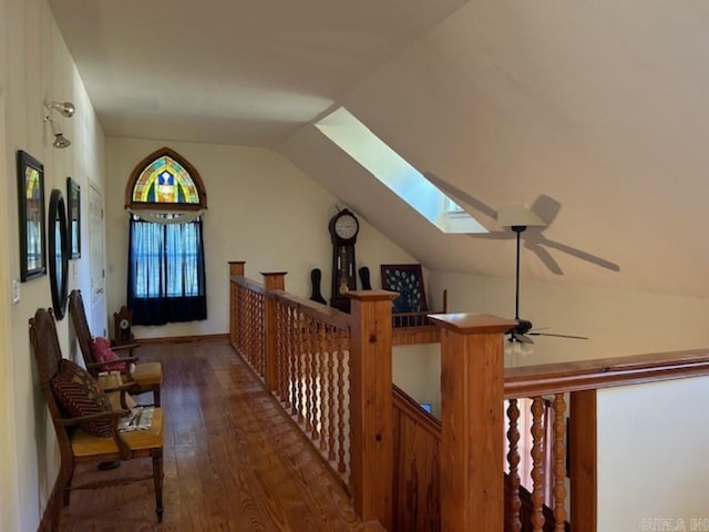 corridor with vaulted ceiling with skylight and dark hardwood / wood-style floors