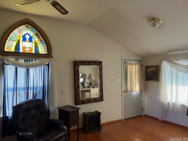 living area with lofted ceiling, hardwood / wood-style flooring, a healthy amount of sunlight, and ceiling fan