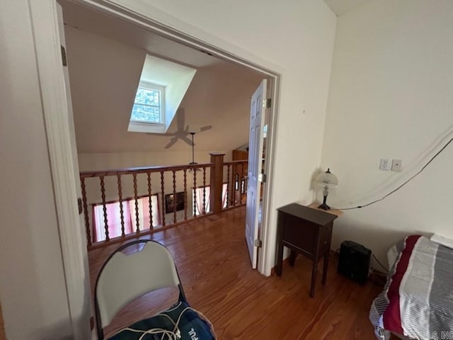 hall with hardwood / wood-style floors and vaulted ceiling with skylight