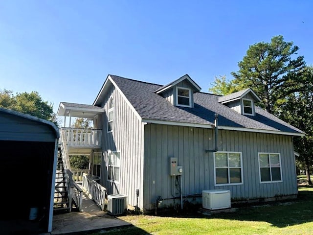 view of side of home with a lawn and central AC unit