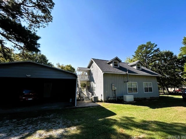 back of property with cooling unit, a yard, and a balcony