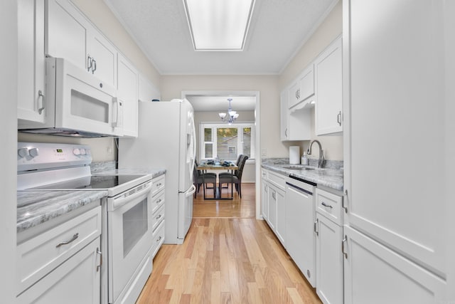 kitchen featuring sink, white cabinets, light wood-type flooring, and white appliances