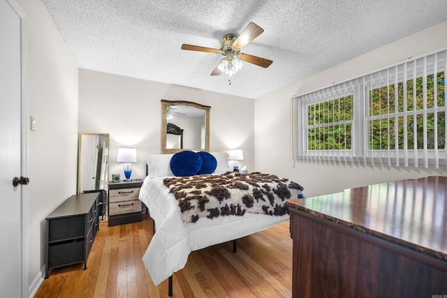 bedroom featuring a textured ceiling, light hardwood / wood-style floors, and ceiling fan