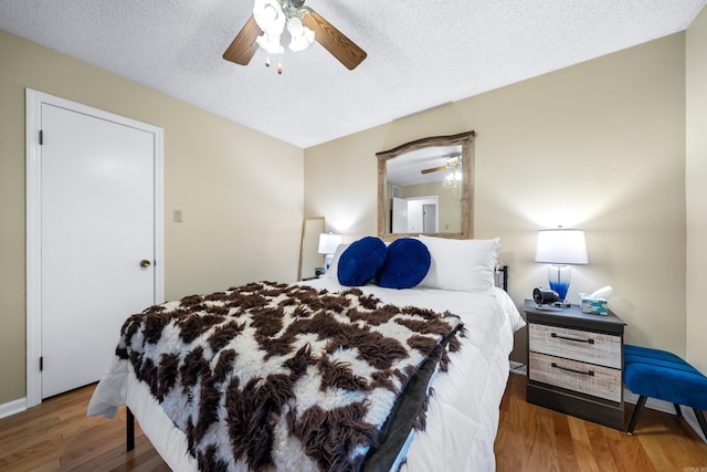 bedroom featuring ceiling fan, a textured ceiling, and dark hardwood / wood-style floors