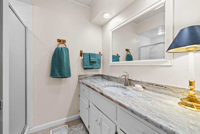 bathroom featuring vanity, an enclosed shower, ornamental molding, and tile patterned floors