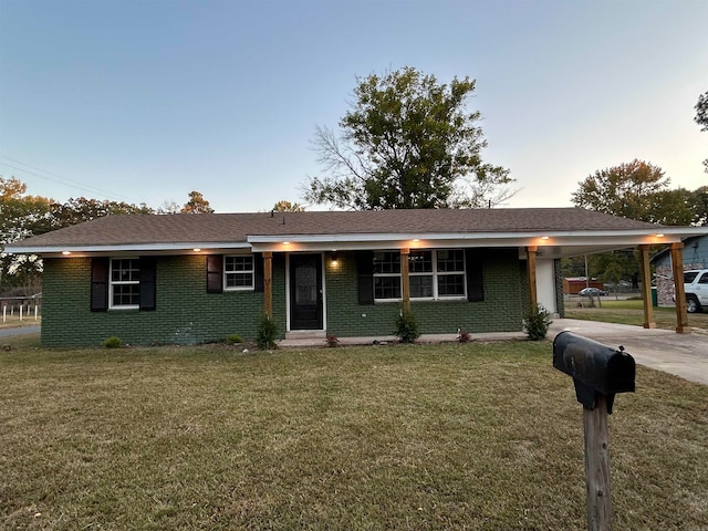 ranch-style house featuring a lawn and a carport