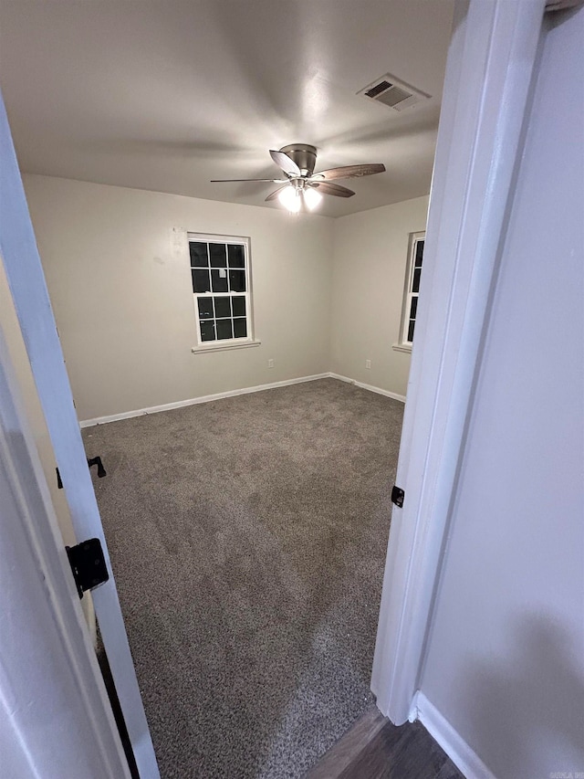 carpeted spare room featuring ceiling fan