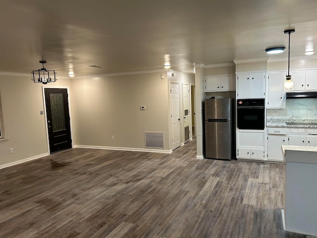 kitchen featuring white cabinetry, black oven, decorative light fixtures, and stainless steel fridge