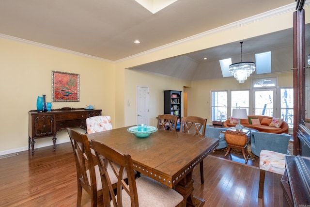 dining room featuring crown molding, a notable chandelier, lofted ceiling, and hardwood / wood-style floors