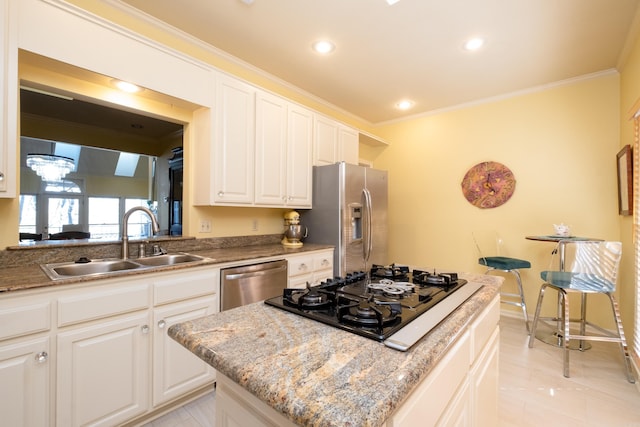 kitchen featuring appliances with stainless steel finishes, white cabinetry, sink, and ornamental molding