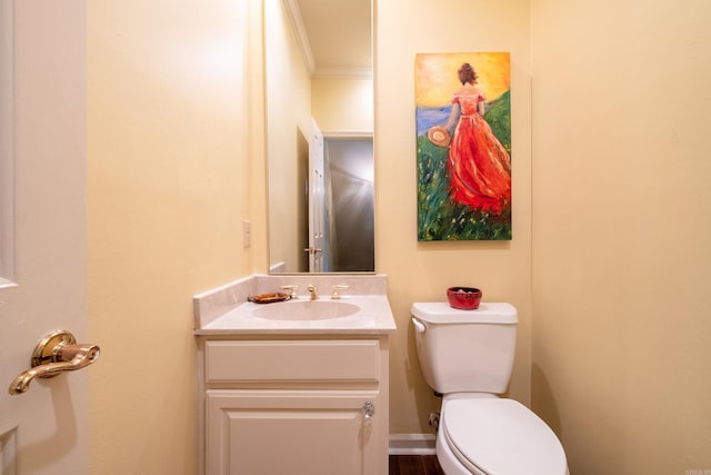 bathroom featuring vanity, ornamental molding, and toilet