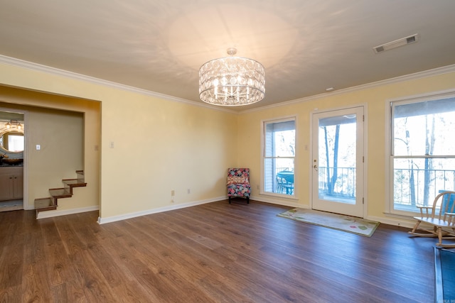 spare room with ornamental molding, dark wood-type flooring, and a chandelier