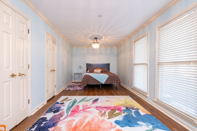 bedroom with dark wood-type flooring, crown molding, and a chandelier