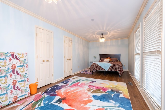 bedroom with crown molding, a notable chandelier, and dark hardwood / wood-style flooring