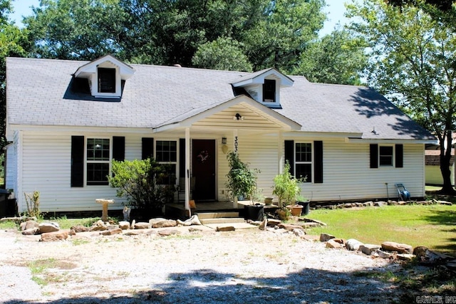 cape cod house featuring a front yard