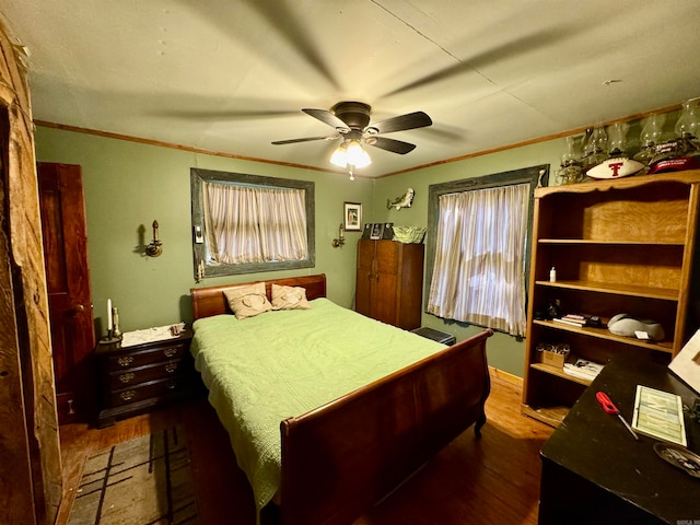 bedroom with ceiling fan, wood-type flooring, and ornamental molding