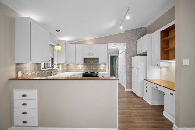 kitchen featuring white cabinets, hanging light fixtures, white refrigerator, and kitchen peninsula