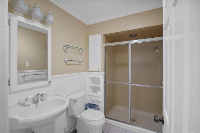 bathroom featuring toilet, tile patterned flooring, sink, and a shower with door