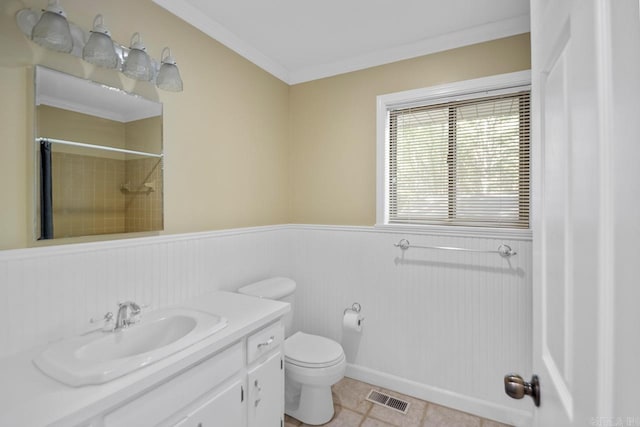 bathroom with tile patterned floors, toilet, crown molding, vanity, and walk in shower