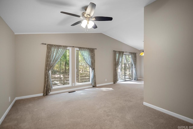 spare room featuring vaulted ceiling, light carpet, a wealth of natural light, and ceiling fan