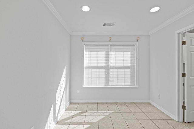 tiled spare room featuring crown molding