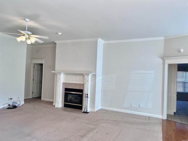 unfurnished living room featuring ornamental molding, a fireplace, light colored carpet, and ceiling fan