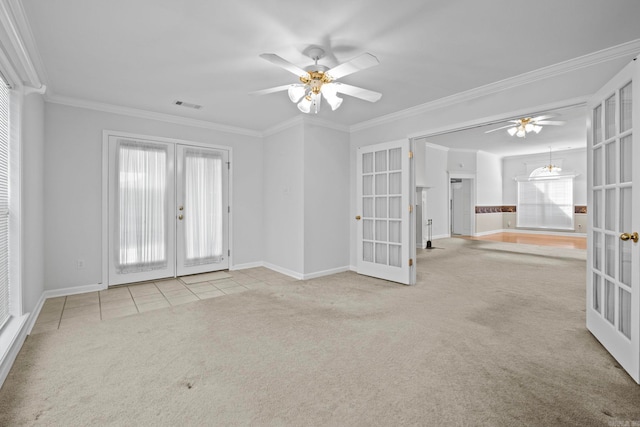 carpeted empty room featuring french doors, crown molding, a healthy amount of sunlight, and ceiling fan